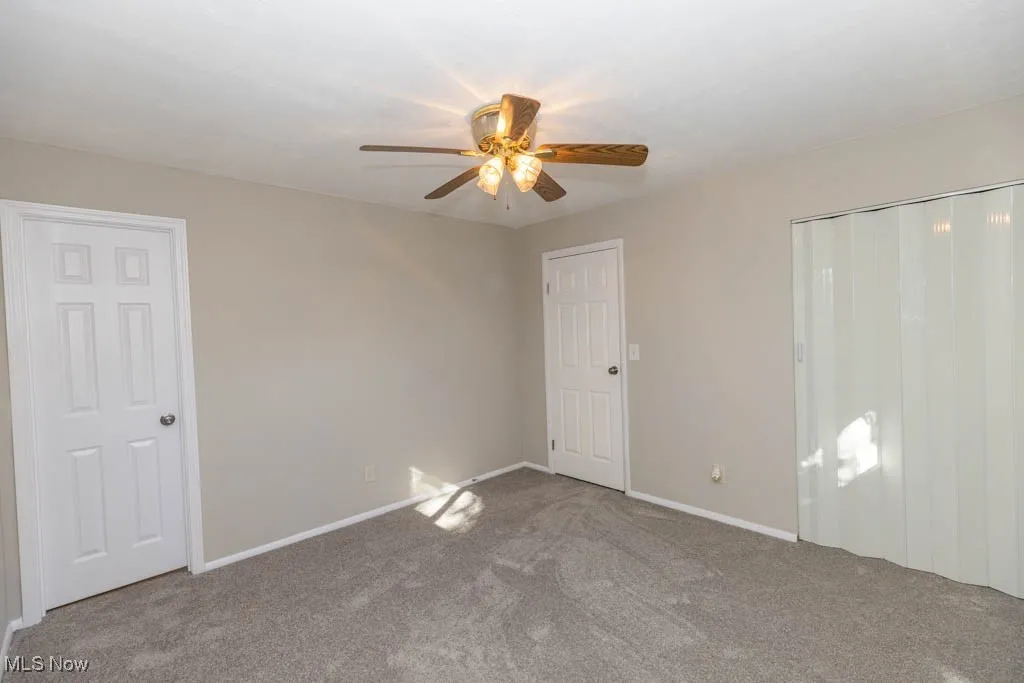 Unfurnished bedroom with carpet flooring, ceiling fan, and a closet