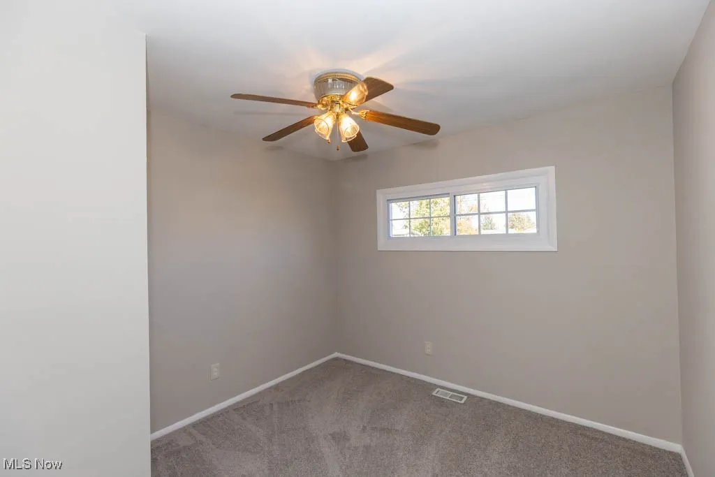 Spare room with light carpet and ceiling fan