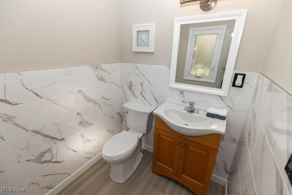 Bathroom with vanity, tile walls, and wainscoting