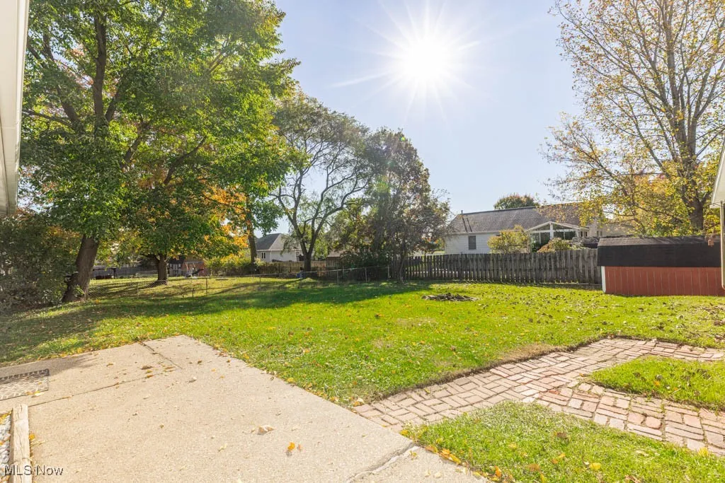 Fenced backyard with a shed and a patio