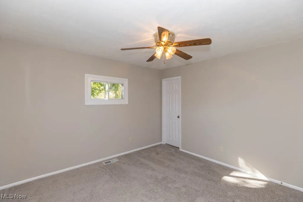 Unfurnished room with light carpet and a ceiling fan