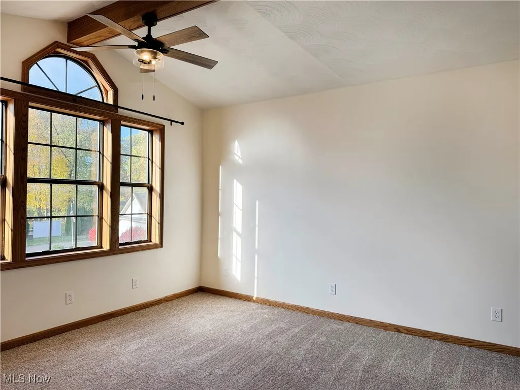 Carpeted bedroom featuring a ceiling fan and baseboards