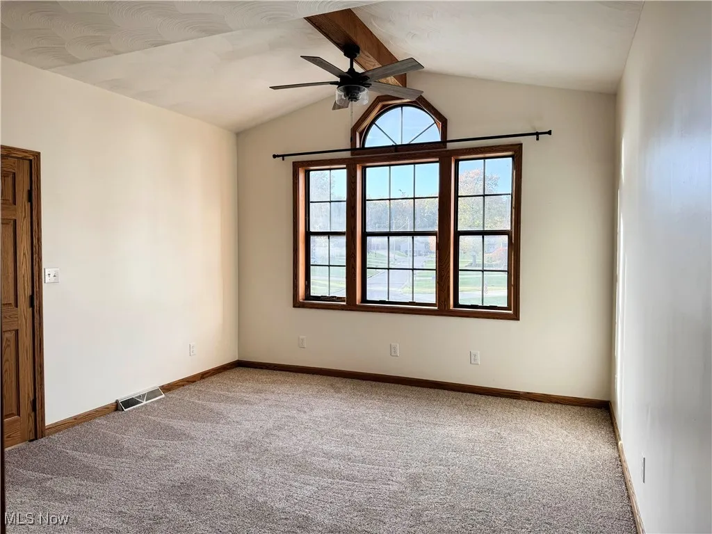 Carpeted bedroom featuring ceiling fan and baseboards