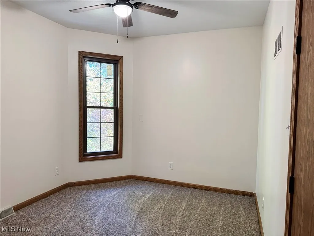Carpeted bedroom with baseboards and a ceiling fan
