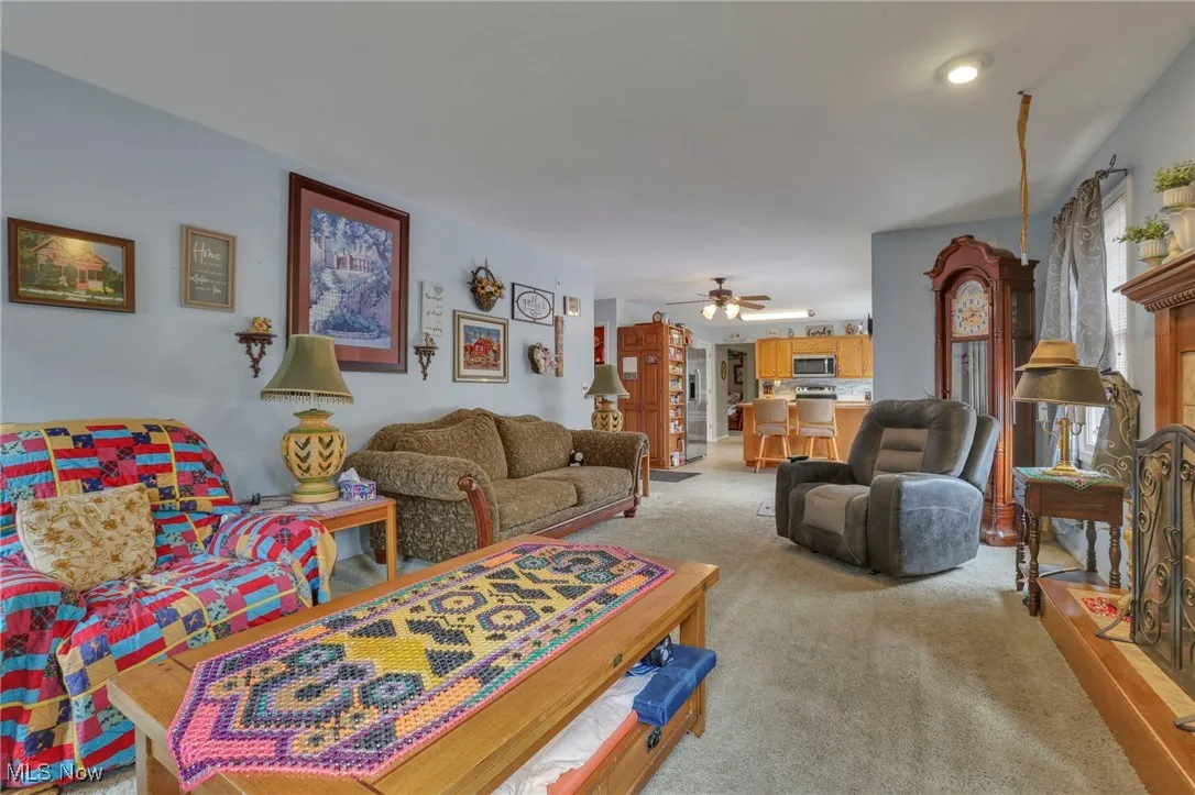 Carpeted living area with ceiling fan