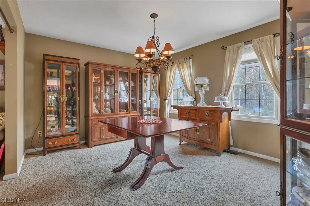 Dining room with light colored carpet and a chandelier