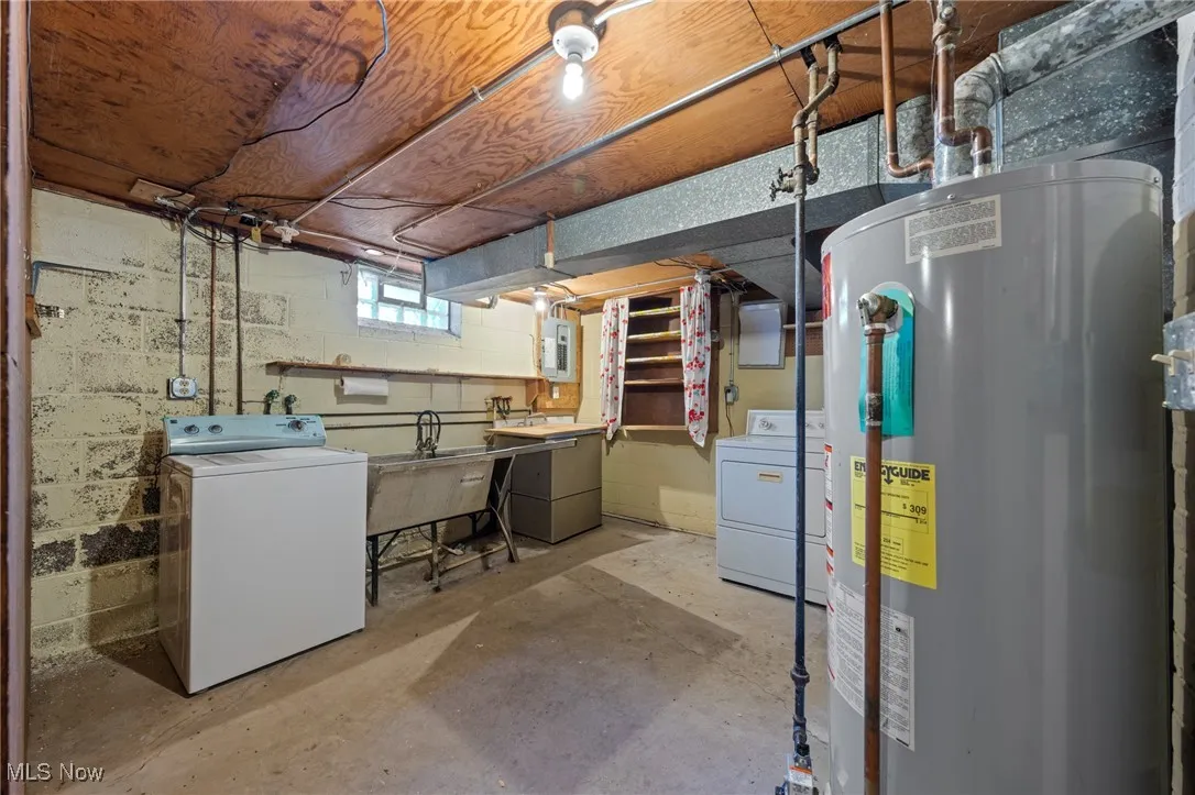 Below grade area featuring water heater, electric panel, and independent washer and dryer