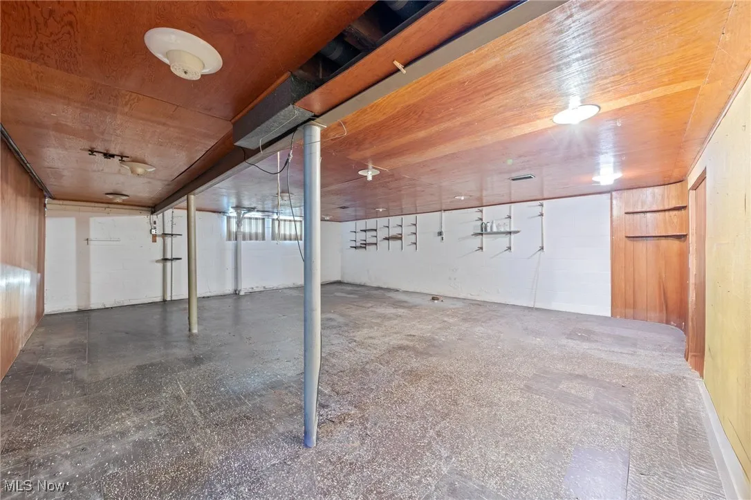 Unfinished below grade area featuring wood walls