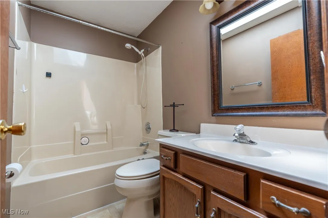 Bathroom with vanity,  shower combination, and light tile patterned flooring