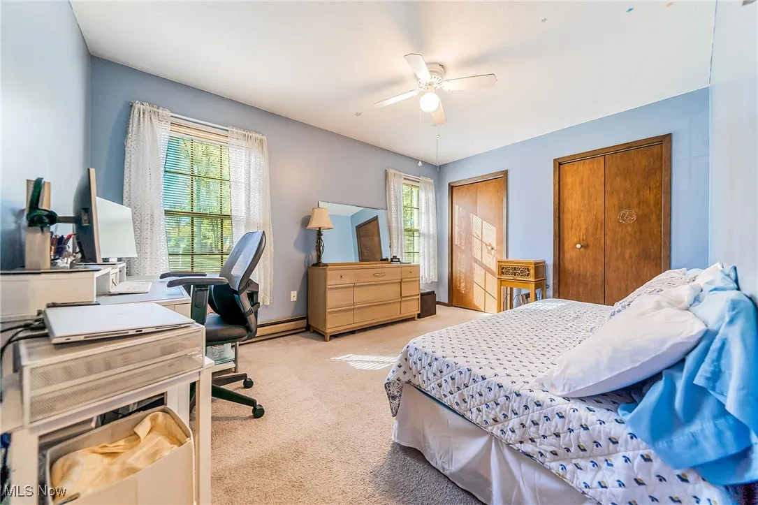 Bedroom featuring a closet, a desk, carpet flooring, and a ceiling fan