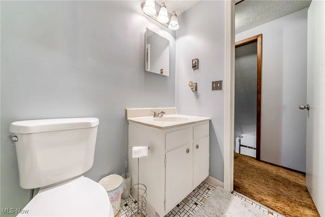 Bathroom with vanity, a textured ceiling, and light tile patterned floors