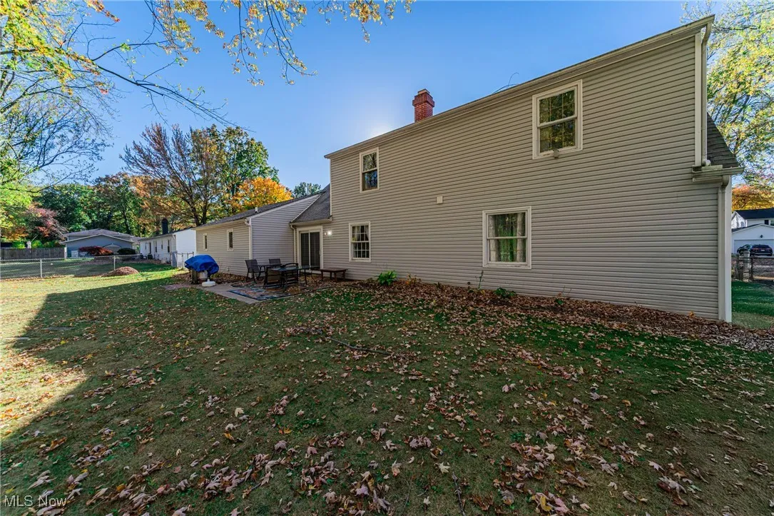 Rear view of house with a patio and a chimney
