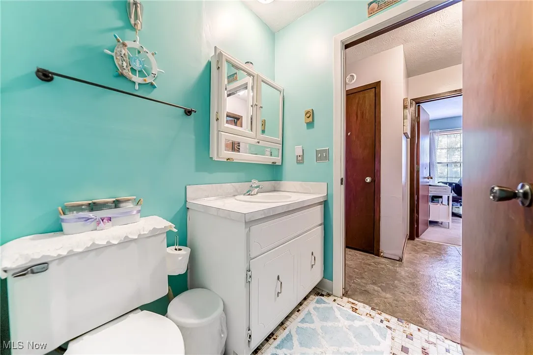 Half bath featuring vanity and baseboards
