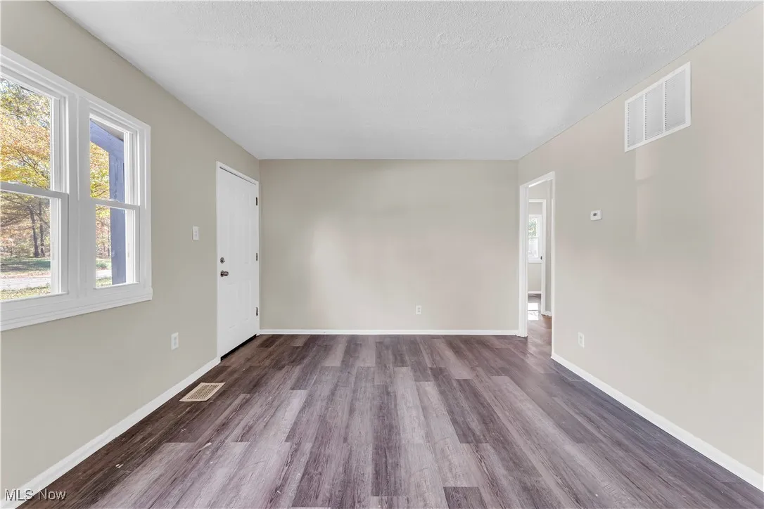 Unfurnished room featuring dark wood-style floors and a textured ceiling