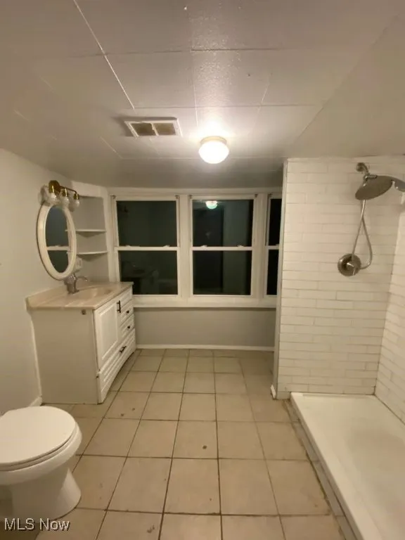 Bathroom with light tile patterned flooring, vanity, and a stall shower