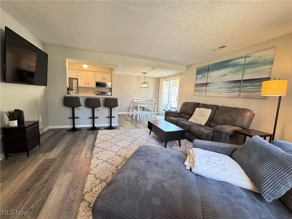 Living room featuring a textured ceiling and LVT flooring