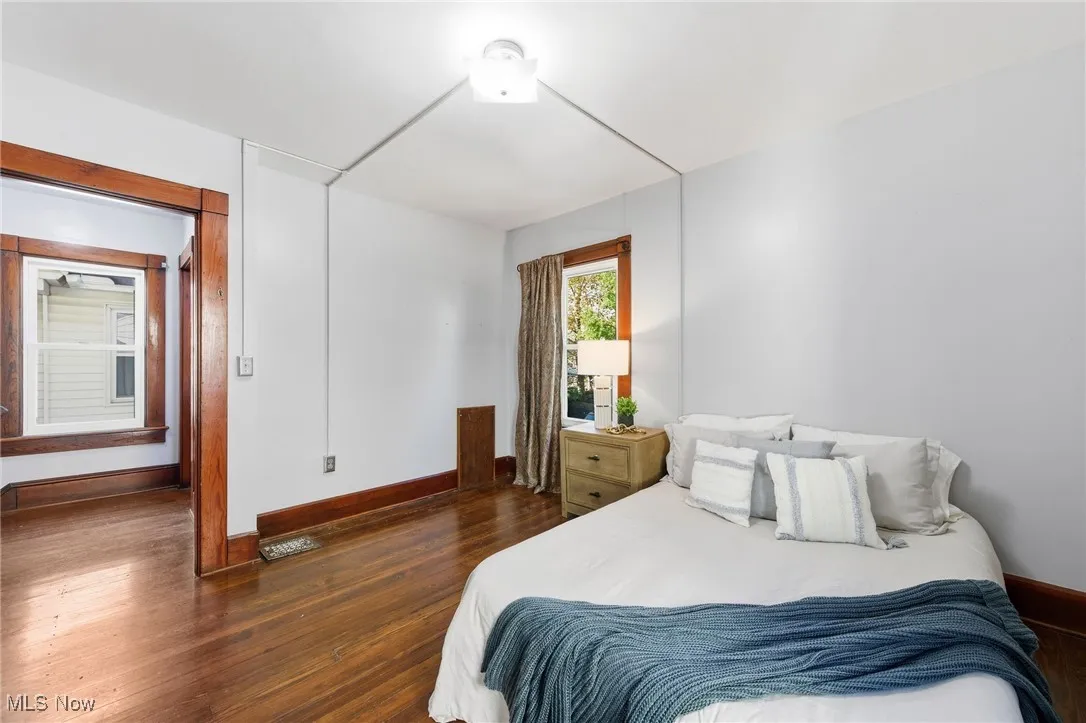 Bedroom featuring dark wood-style flooring and baseboards