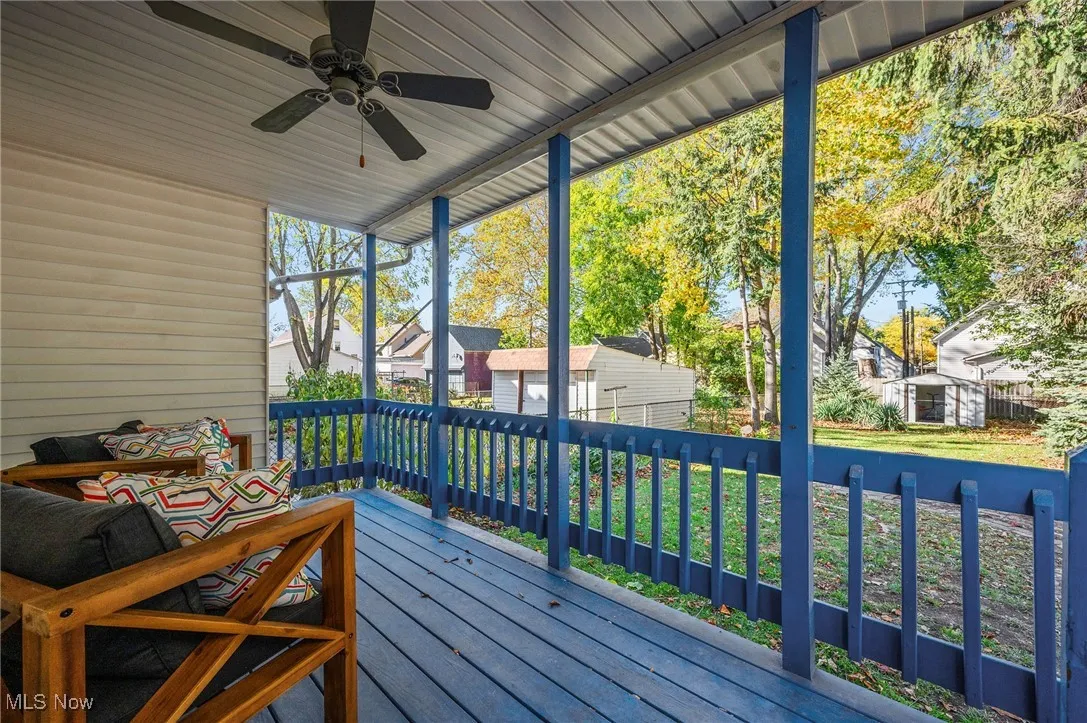 Deck featuring a storage unit, a lawn, a residential view, and ceiling fan