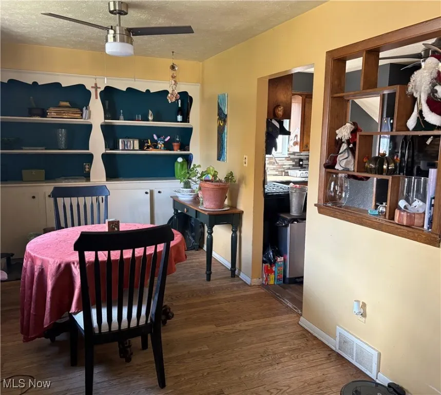 Dining area with wood finished floors and a textured ceiling