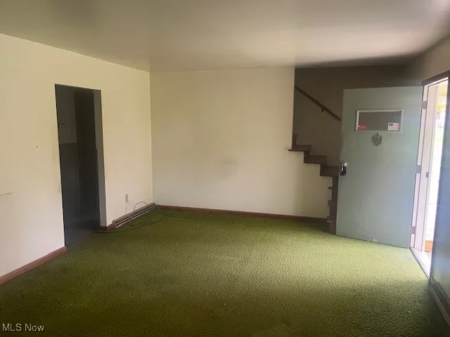 Unfurnished room with stairs and carpet flooring