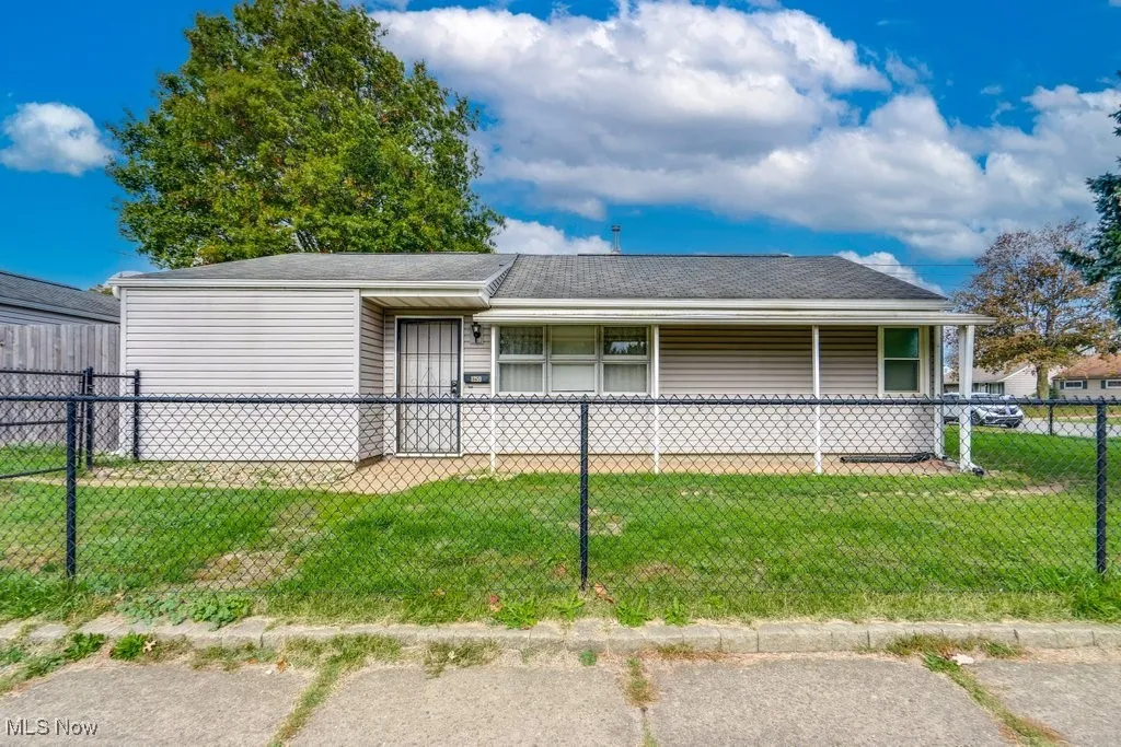 View of front of property featuring a fenced front yard and a shingled roof
