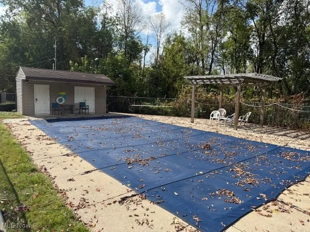 View of swimming pool with view of wooded area and a patio area