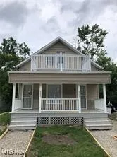 Back of house with a porch and a balcony