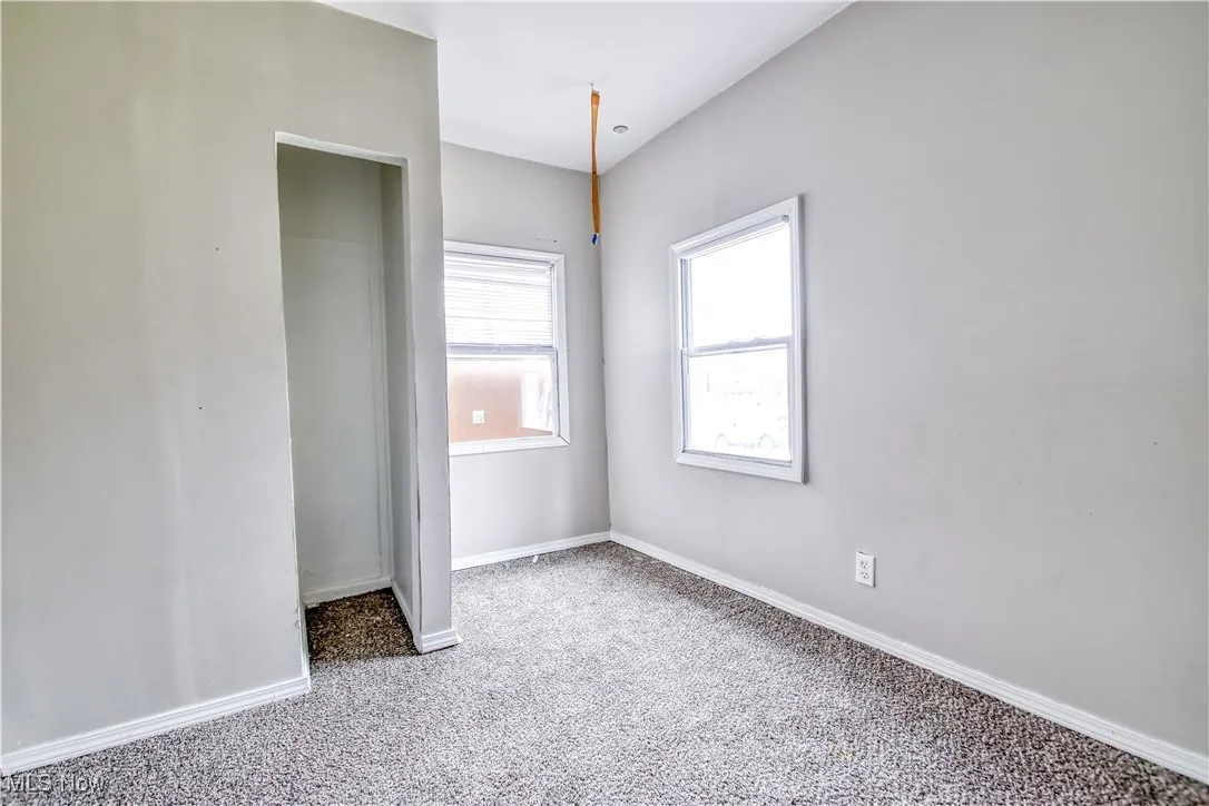 Unfurnished bedroom featuring light colored carpet and baseboards