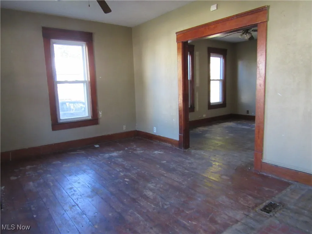 Unfurnished room featuring ceiling fan and dark wood finished floors