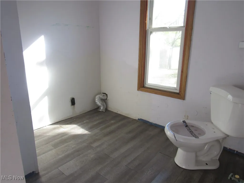 Bathroom with dark wood-style flooring and toilet
