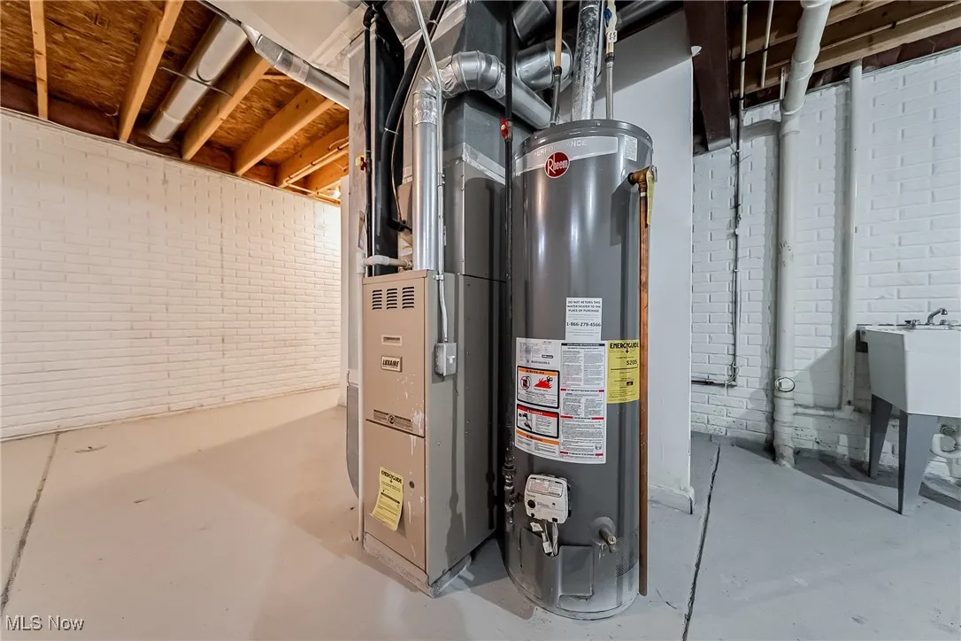 Utility room featuring water heater and heating unit