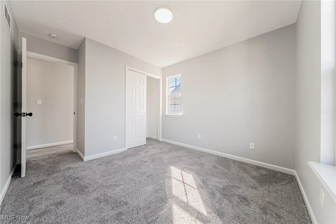 Unfurnished bedroom with carpet flooring and a closet