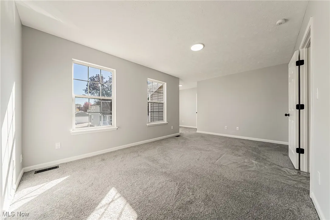 Carpeted empty room with baseboards