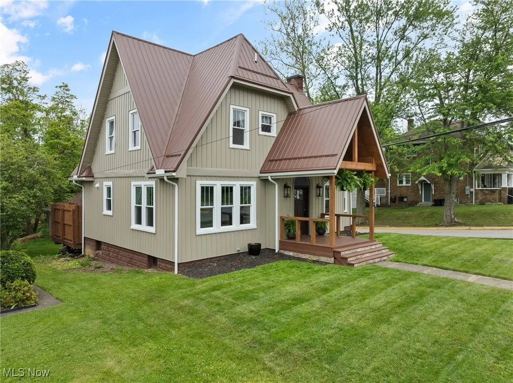 Back of property with a yard and a metal roof