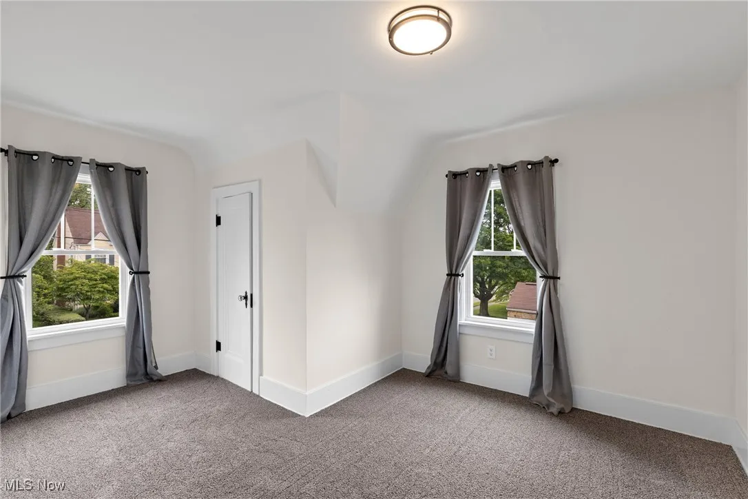 Bonus room with carpet flooring, plenty of natural light, and lofted ceiling