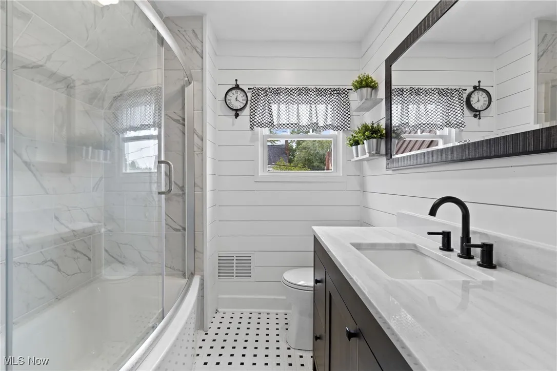 Bathroom featuring vanity and combined bath / shower with glass door