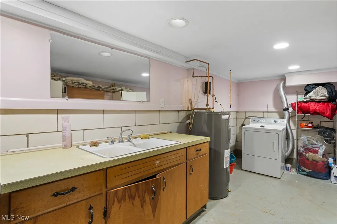 Washroom with washer / dryer, electric water heater, concrete floors, and recessed lighting