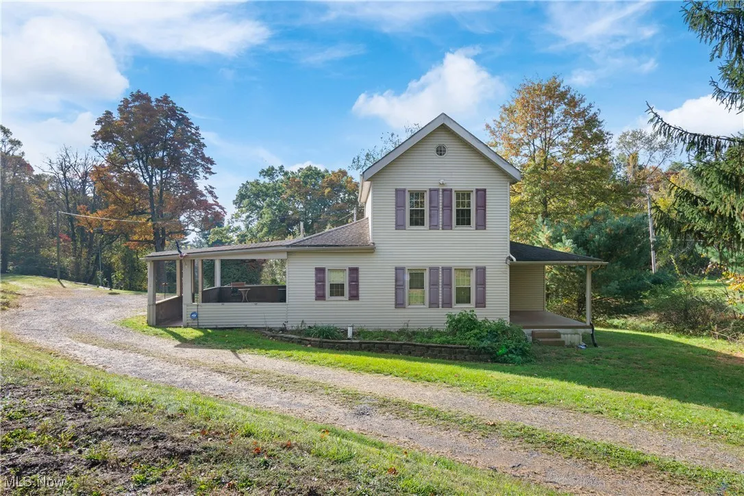 Traditional home featuring a front lawn, driveway, and a shingled roof