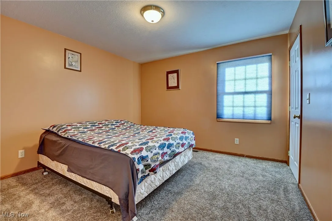 Bedroom featuring carpet and a textured ceiling