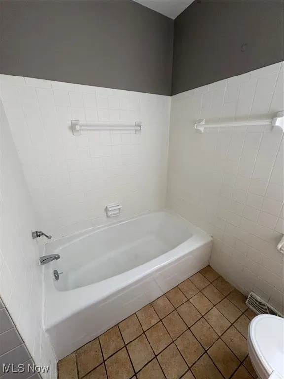 Full bath featuring tile patterned floors and a tub