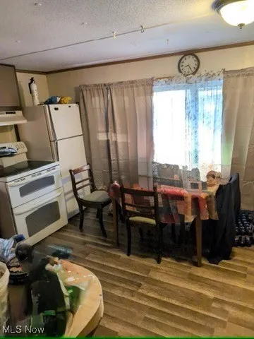 Dining space featuring dark wood-type flooring and a textured ceiling