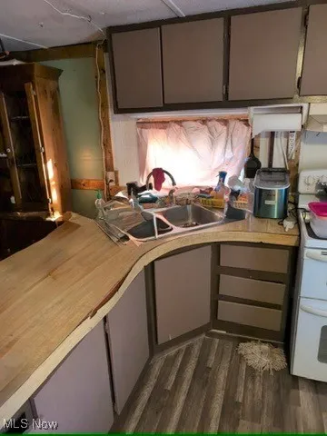 Kitchen with light countertops, white range oven, dark wood finished floors, gray cabinets, and extractor fan