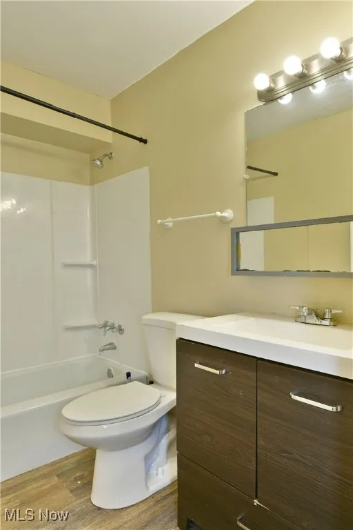 Bathroom with vanity, light wood-type flooring, and bathtub / shower combination