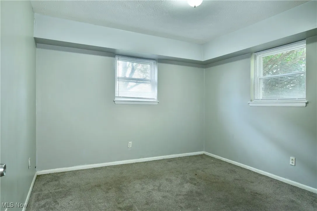 Empty room featuring carpet flooring and a textured ceiling