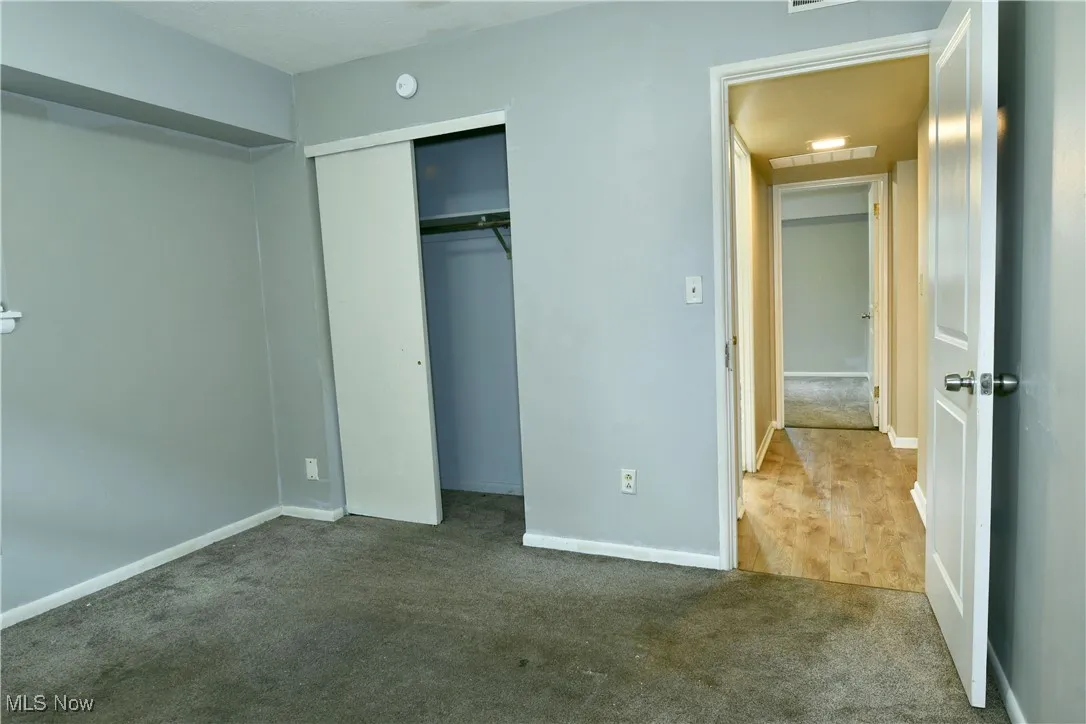Unfurnished bedroom with carpet and a closet