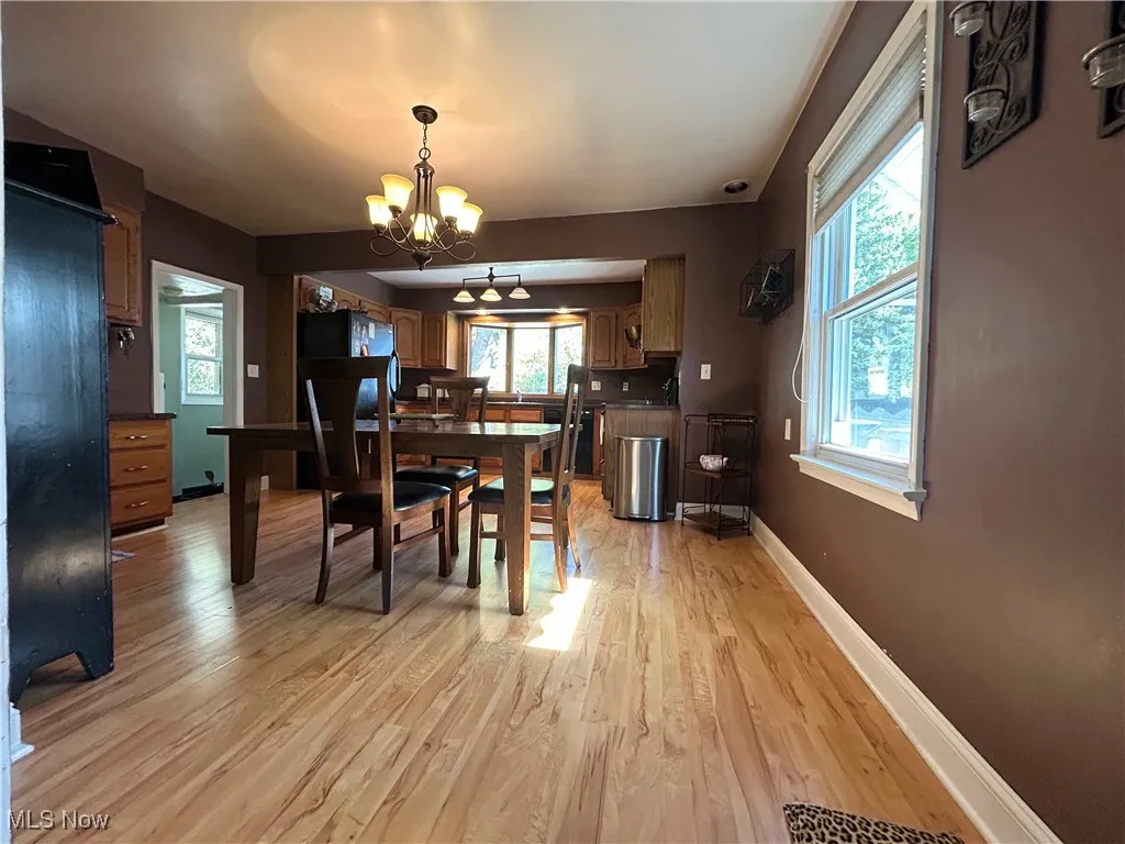 Dining room with light wood-style flooring and a chandelier