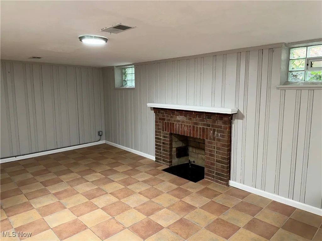 Below grade area featuring a fireplace and wooden walls