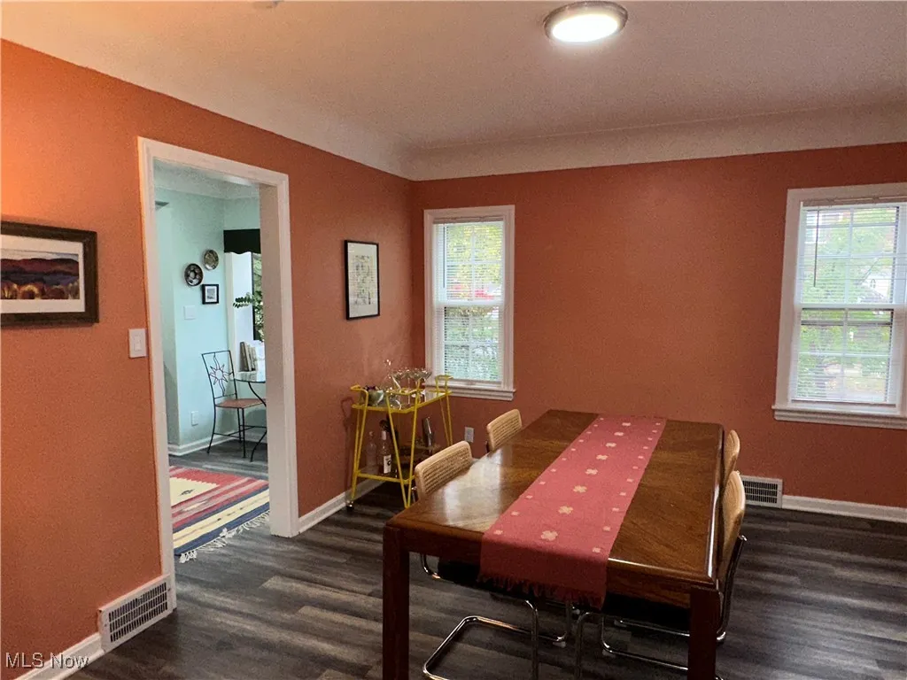 Dining space featuring baseboards and dark wood-type flooring