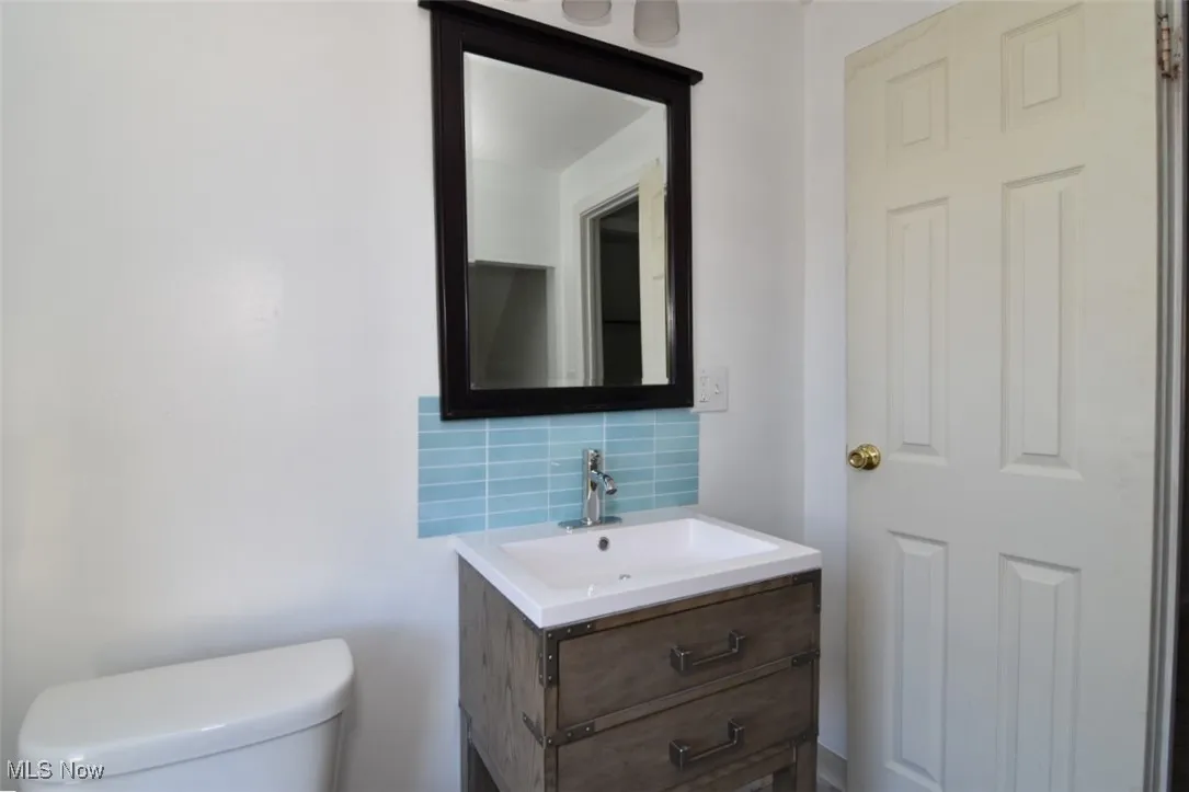 Bathroom featuring tasteful backsplash and vanity