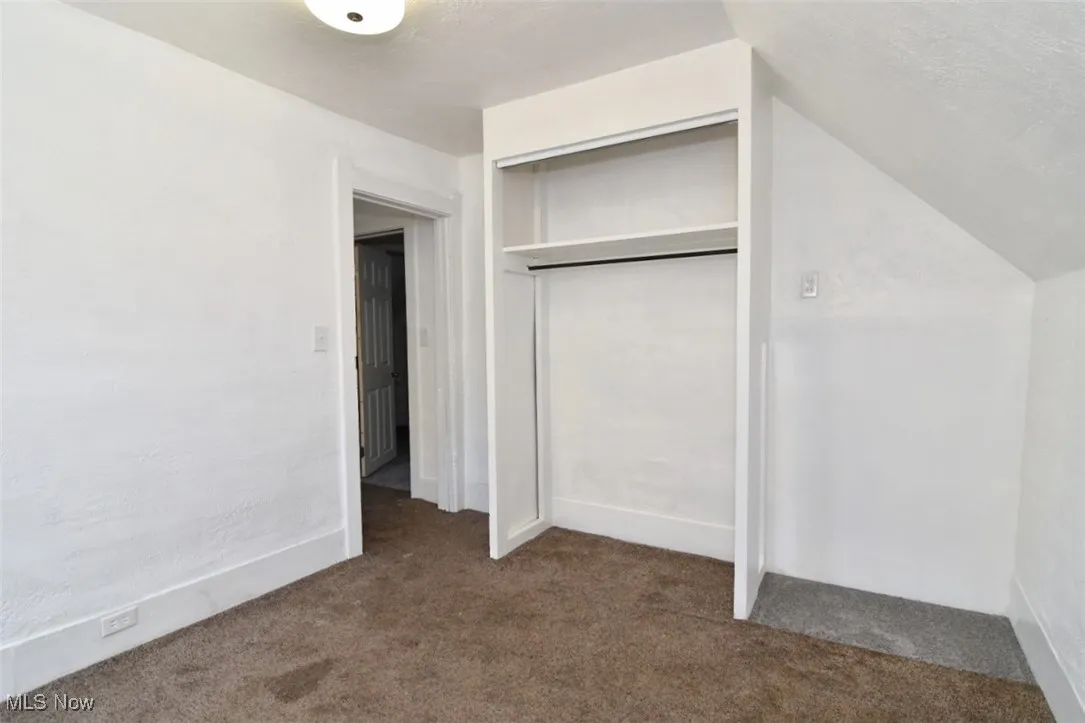 Unfurnished bedroom with carpet, a closet, and a textured ceiling